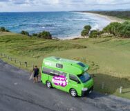 Jucy Condo Australië man met surfplank en de zee op de achtergrond