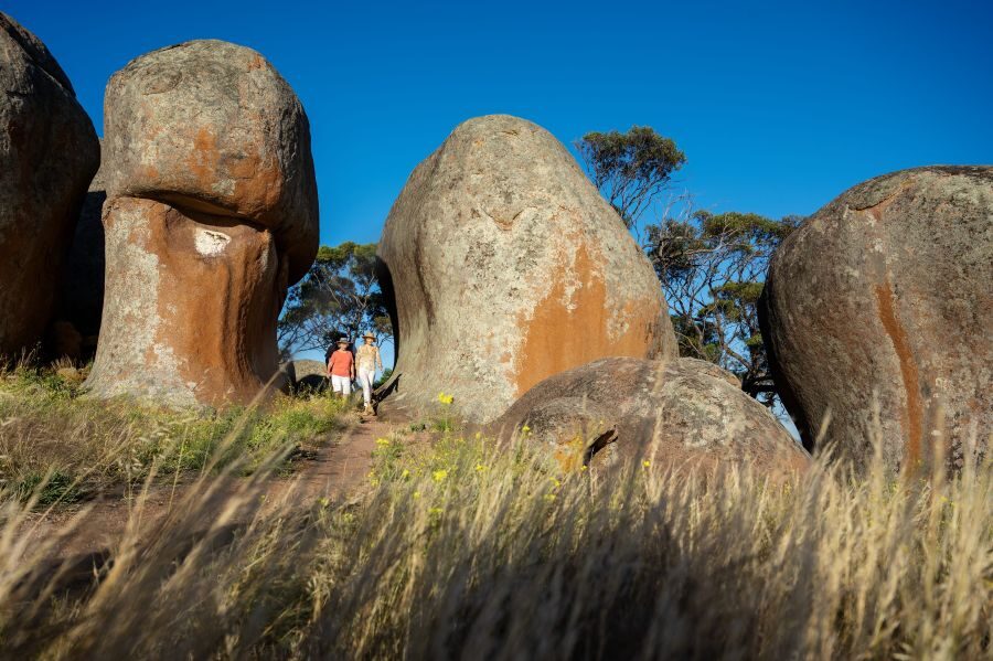 Man en vrouw lopen tussen de rotsen van Murphy's Haystacks in South Australia