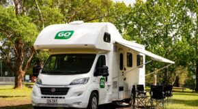 Go Cheap Derwent staat geparkeerd op een camping, stoelen buiten onder de luifel