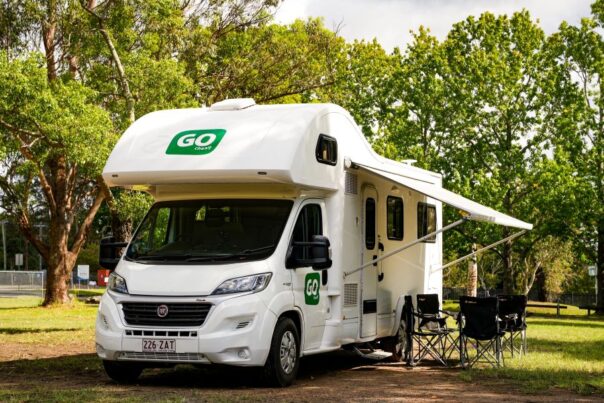 Go Cheap Derwent staat geparkeerd op een camping, stoelen buiten onder de luifel