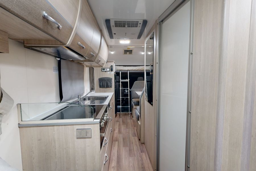 Zicht op de keuken en het interieur van de Go Cheap Henty vanuit de zithoek achterin