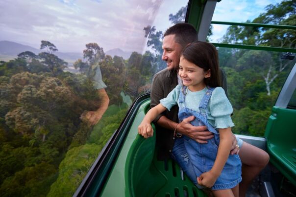 Vader en dochter kijken naar buiten vanuit de Kuranda Skyrail bij Cairns
