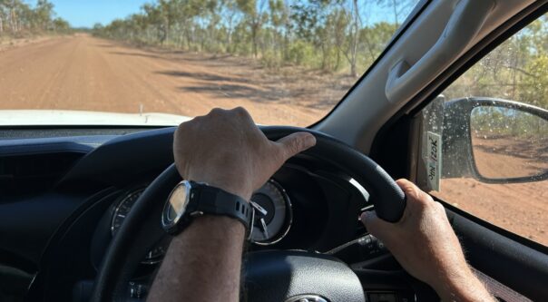Man rijdt in een camper in de Outback op een gravelweg in Australië