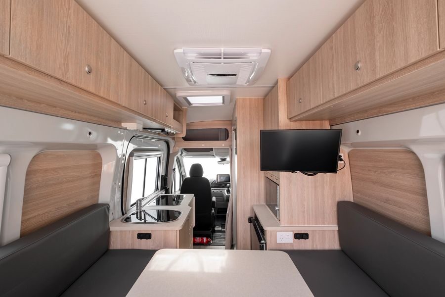 Britz Trailblazer Australië interieur camper met zicht van achter naar voren inclusief zithoek en tv