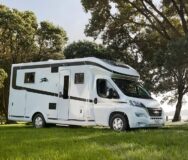 De zijkant van de Britz Wanderer camper geparkeerd op een grasveld in Nieuw-Zeeland