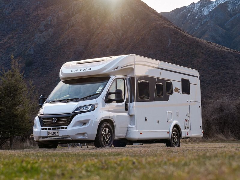 De Britz Odyssey camper geparkeerd op een grasveld tussen de bergen in Nieuw-Zeeland