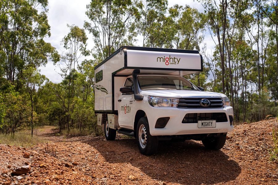 De voorkant van de Mighty 4WD camper die rijdt over een onverharde weg in Australië