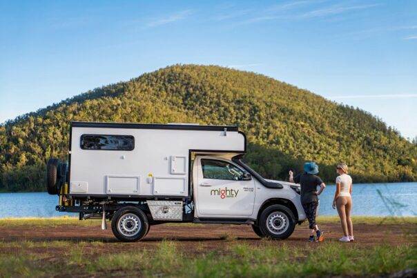 De zijkant van de geparkeerde Mighty 4WD camper met twee personen kijkend naar het uitzicht in Australië