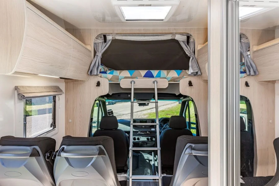 De ladder naar het tweepersoonsbed in de alkoof boven de cabine van de Pacific Horizon Sam 6 camper