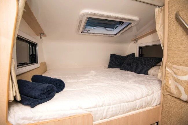 Het bed in de alkoof van de Leisure Rent 4 Berth Motorhome is opgemaakt