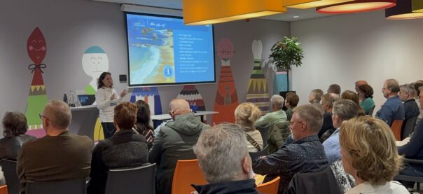 Informatiedag Campers Down Under, zaal vol met gasten, Karin presenteert