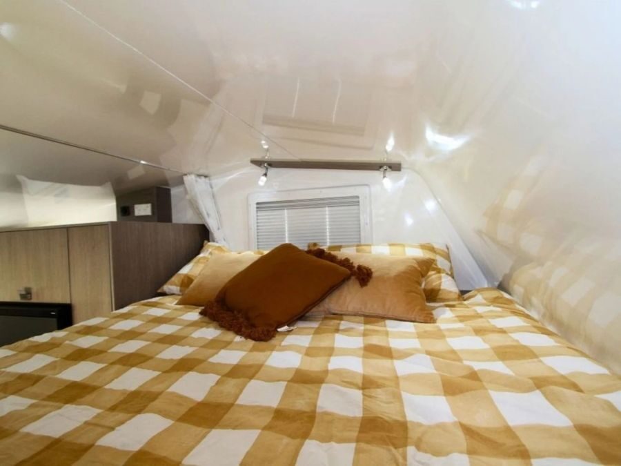 Het bed in de alkoof van de Leisure Rent Deluxe Motorhome is opgemaakt