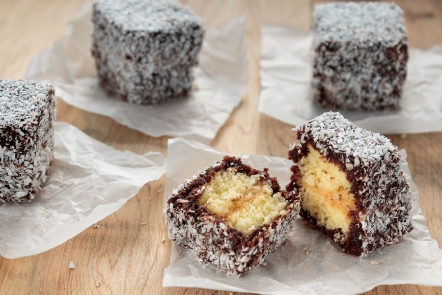 Aangesneden Australische lamingtoncake op een houten tafel
