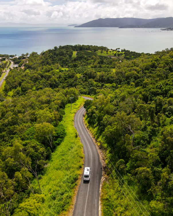 Apollo Euro Tourer rijdt op de weg tussen de bomen op weg naar de zee in Queensland Australië
