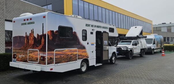 Mensen bezichtigen 3 campers (een 4WD van Red Sands, een Maui Ultima Olus Camper en een Cruise America camper van binnen en buiten tijdens Informatiedag Campers Down Under in Utrecht