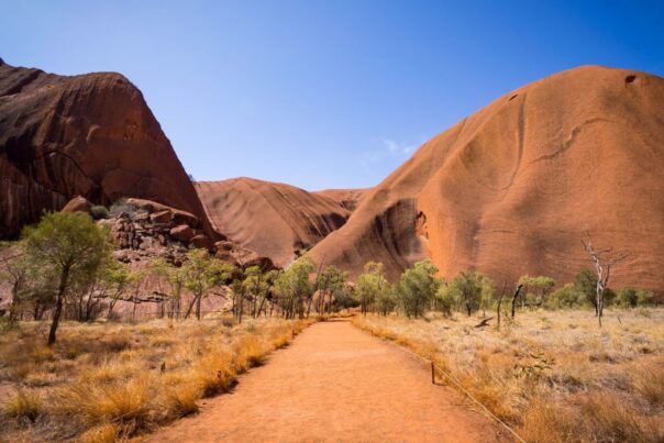 Zicht op Uluru-Ayers-Rock in het Red Centre vanaf een gravelweg